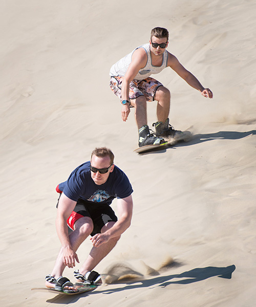 Two young men sandboarding