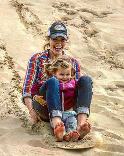 Mother and daughter sand sledding